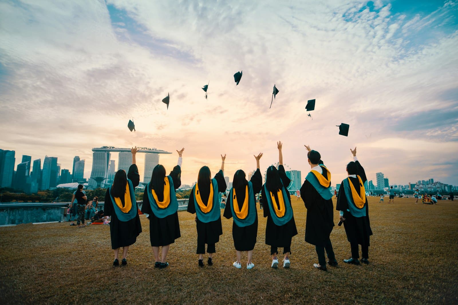 Graduates in gowns tossing their caps into the air