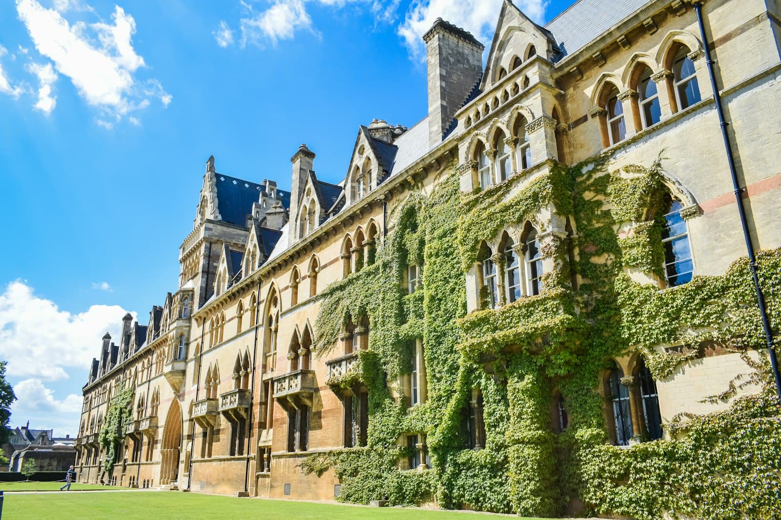 An ivy-covered Gothic college building under a blue sky