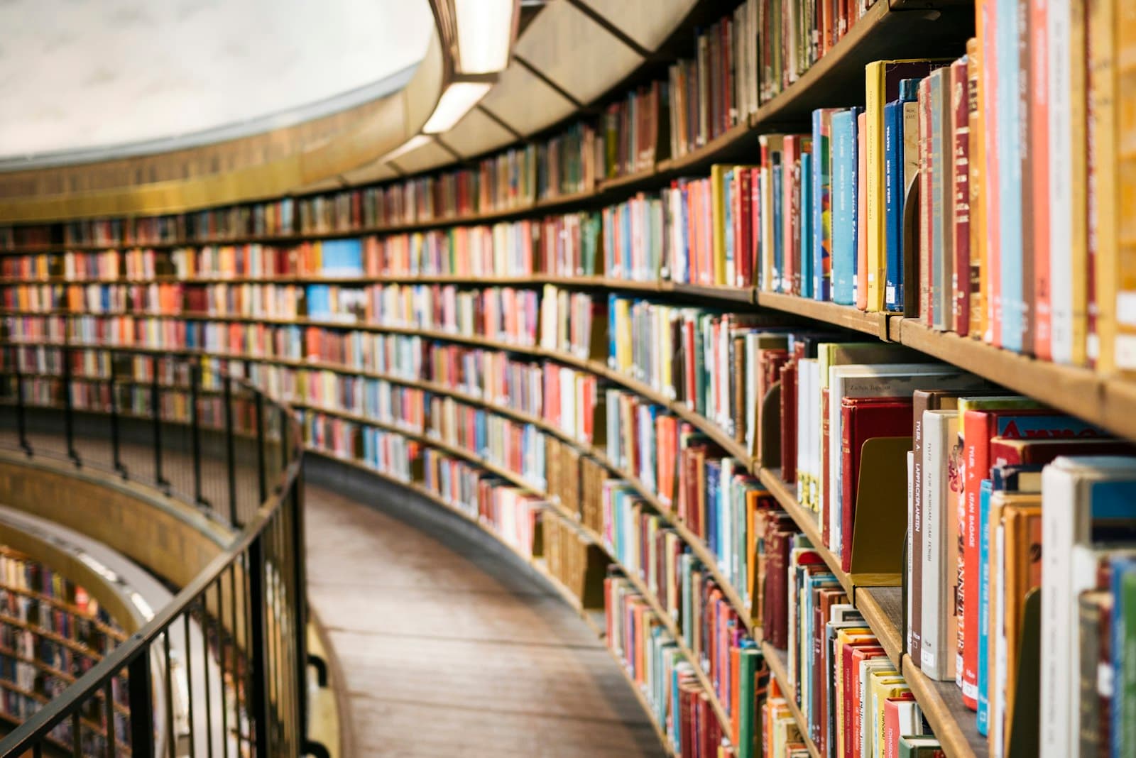 A curved library wall lined with colourful books